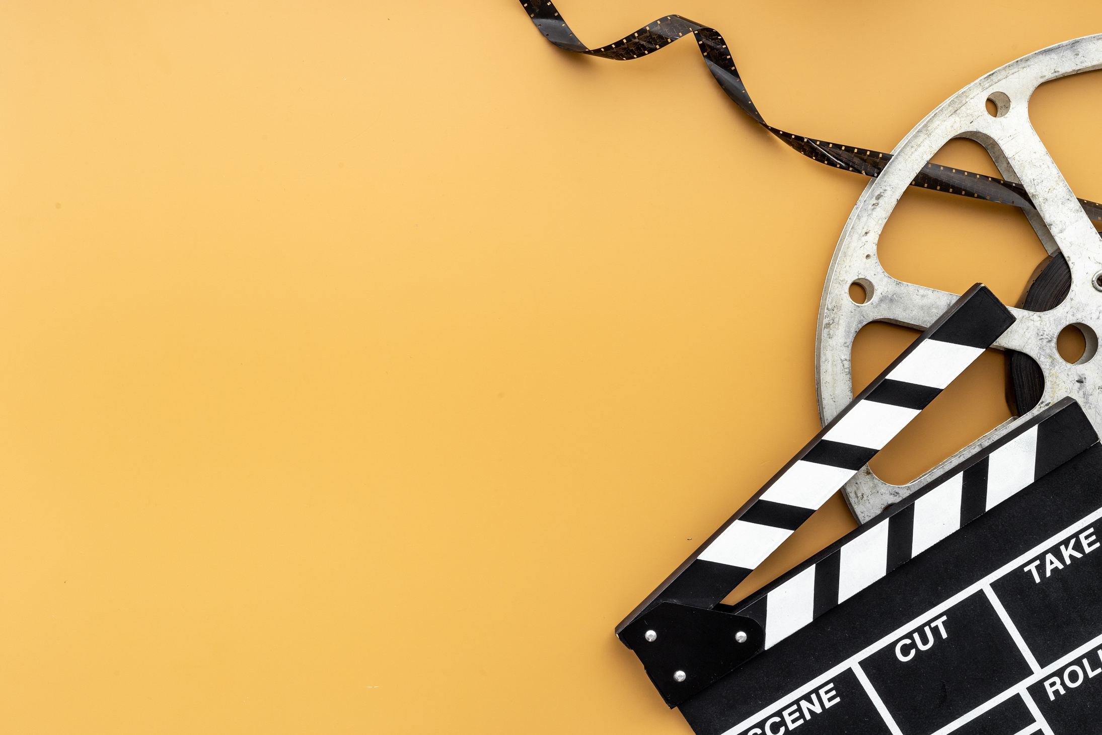Cinema background with movie clapperboard and film reel